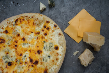four cheese pizza on a gray background with cheese macro photo
