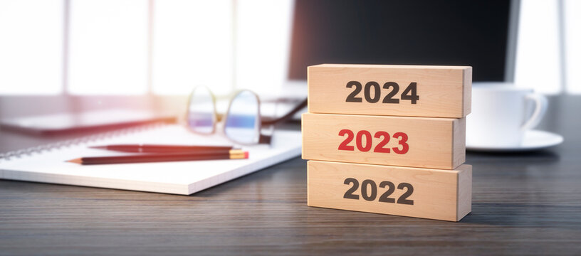 3D render of a stacked wooden blocks with year number 2022 2023 2024 on a office workplace background - 3D illustration