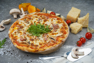 pizza with mushrooms on a gray background with tomatoes and cheese
