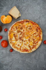 Margherita pizza on a gray background with tomatoes and cheese, vertical photo
