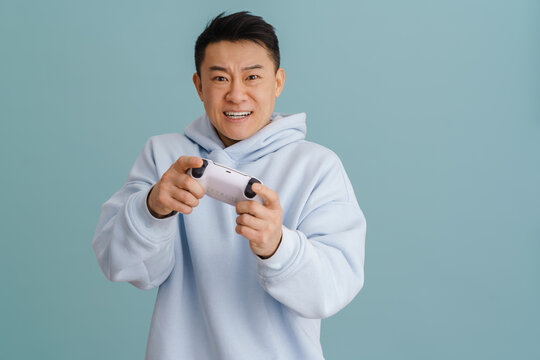 Asian Angry Man Grimacing While Playing Video Game With Joystick