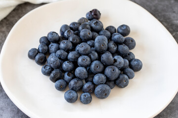 Blueberries on a dark background. Fresh blueberries on the plate. close up