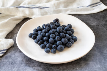 Blueberries on a dark background. Fresh blueberries on the plate. close up