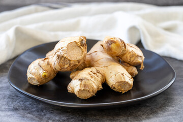 Jerusalem artichoke on dark background. Fresh jerusalem artichoke on plate. Organic food. close up