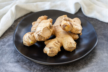 Jerusalem artichoke on dark background. Fresh jerusalem artichoke on plate. Organic food. close up