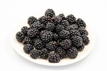 Black mulberry isolated on white background. Fresh and juicy black mulberry on the plate. Organic food. close up