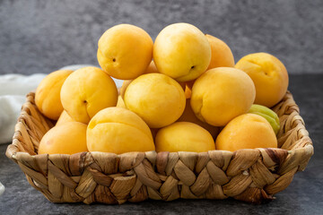 Ripe apricots on a dark background. Fresh and juicy apricots in the basket. Organic food. close up