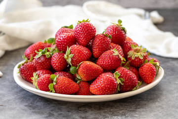 Ripe strawberries on a dark background. Fresh strawberries on the plate. Organic food. close up