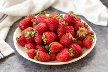 Ripe strawberries on a dark background. Fresh strawberries on the plate. Organic food. close up