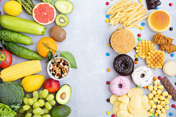 Flat lay of Healthy and unhealthy food from fruits and vegetables vs fast food, sweets and pastry...