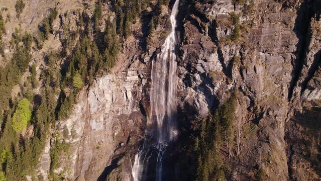 aerial drone footage raising down a stunning waterfall in Grindelwald in the Swiss Alps