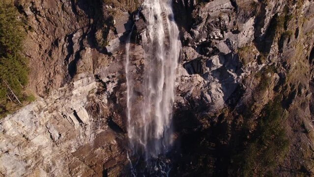 aerial drone footage panning down a picturesque waterfall in Grindelwald in the Swiss Alps