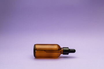 Facial serum on purple background, cosmetics subject