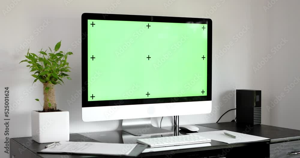 Poster desktop computer monitor standing on a desk with a green screen