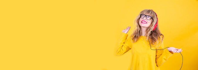 happy mature woman dancing with headphones and copy space