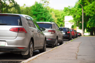 A group of parked cars along the road. Back view.