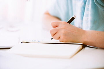 Side view of woman using fountain pen writing in her notebook