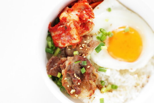 Korean food, barbecue beef and kimchi with sunny side up fried egg on rice for comfort food image 