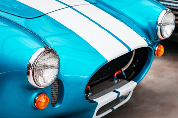 Close-up of a retro racing car. Headlights and part of the hood.