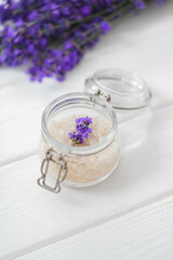 Obraz na płótnie Canvas Lavender bath salt and dried flowers of lavender on white wooden background