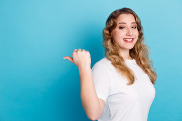 Fototapeta premium Photo of charming young woman dressed shirt smiling pointing finger empty space isolated blue color background