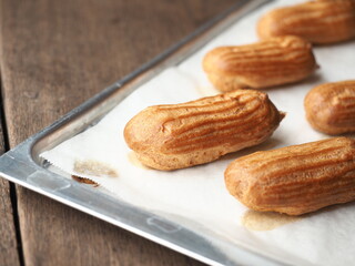 baked homemade eclairs on baking tray 