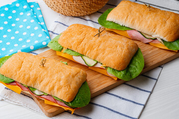 Sandwich with ham and cheese on wooden board