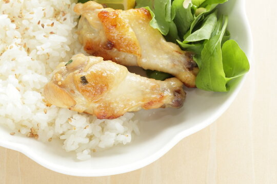 Barbecue chicken drumsticks on sesame rice with baby leaves salad for asian food image