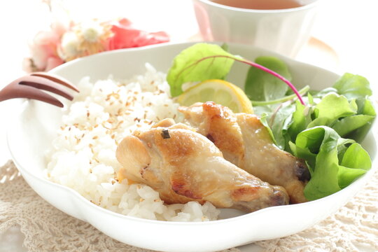 Barbecue chicken drumsticks on sesame rice with baby leaves salad for asian food image