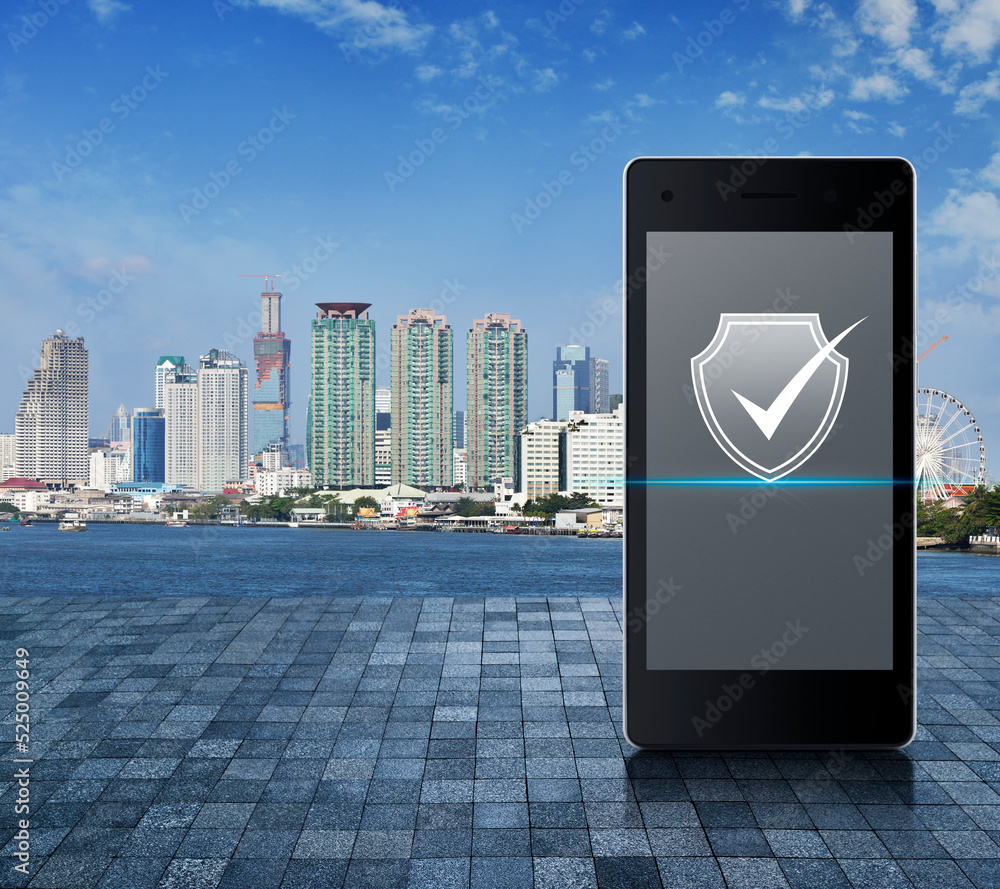 Poster security shield with check mark icon on modern smart mobile phone screen on stone tile floor over ci