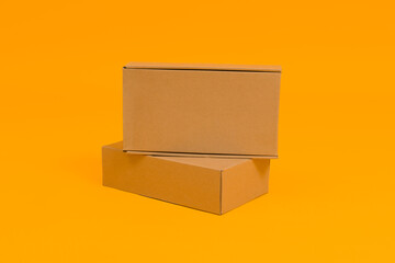 two cardboard boxes on a yellow background, the concept of delivery or moving