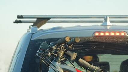 Bicycles are attached to the trunk of the car. Close Up