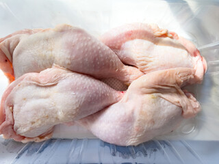 Close-up of plastic package with four organic bio raw chicken legs