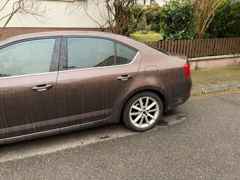 Side view of brown dirty car from sahara dust after storm Celia in France, Europe