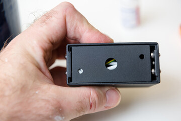 Male hand holding black luminare componenent