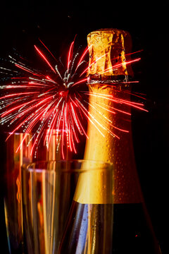 Bottle of champagne against exploding fireworks