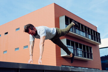 Athletic man doing parkour exercises outdoors