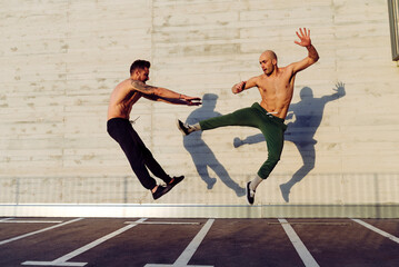 Young men practicing fly kick outdoors