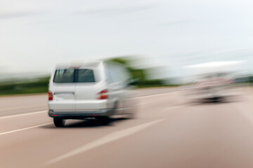 Fototapeta na wymiar Rear view of unrecognizable blur view of white wagon van driving on highway autobahn