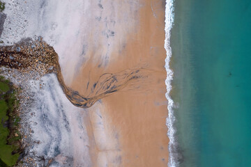 Aerial top down view on a beautiful beach and ocean surface with blue water. Keem bay, Ireland....
