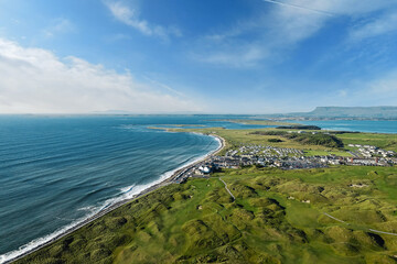 View on a Strandhill town and beach in county Sligo, Ireland. Warm sunny day with blue cloudy sky. Popular travel area with stunning nature scenery. High tide.