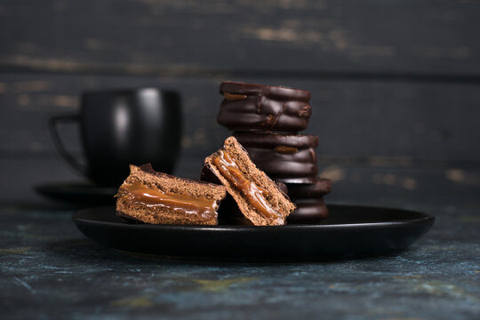 Chocolate alfajores and dulce de leche near hot chocolate