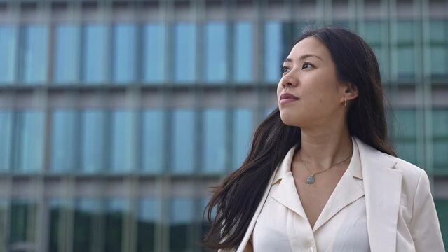 Young asian professional woman wearing elegant blazer looking to the side - Inspired female in corporate office city - Business Inspiration