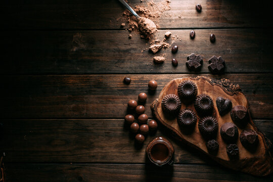 Chocolate pralines and truffles with mousse jar arranged on wooden table