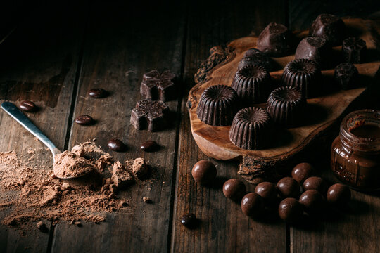 Chocolate pralines and truffles with mousse jar arranged on wooden table