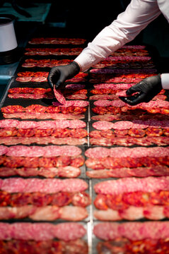 Hands of man folding sausages pieces in sets