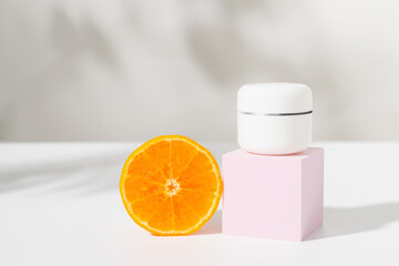 Cream jar with slice of orange, ingredients for skin care and treatment vitamin on white background, Natural cosmetics concept.
