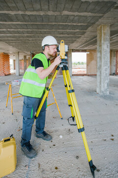 Surveyor engineer working at construction site with measuring eq