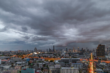 Modern city under dramatic stormy rainy clouds.