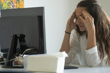 Beautiful worker stressed out at work in front of the pc. Headache. Concept of burn out into office